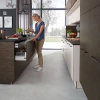 Cuisine moderne avec îlot et armoires effet bois, présentée par Nolte Kitchen.