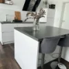 Eine moderne Küche mit Insel und schwarzen Hockern, gestaltet von Nolte Küchen.