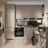 Moderne Küche mit beige Fronten und schwarzer Rückwand, ausgestattet mit Geräten und Dekor, Nolte Küchen.