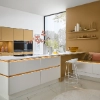 Cuisine moderne avec façades blanches et accents dorés, équipée par Nolte Kitchen.