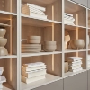 Étagère avec bols décoratifs et livres, élégamment mise en scène avec éclairage, partie de Nolte Living.