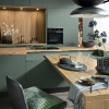 Une cuisine moderne en tons verts avec accents bois et décorations élégantes de Nolte Kitchen.