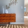 A sideboard with a vase and candles in a sunlit room, Nolte Living.