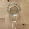 Un verre est attaché avec une corde à un récipient suspendu.