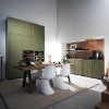 A modern kitchen with green cabinets and dining table, designed by Nolte Kitchen.