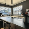 Cuisine moderne avec îlot et tabourets dans une pièce lumineuse, Nolte Kitchen.