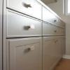 A stylish kitchen with gray cabinets and elegant handles by Nolte Kitchen.