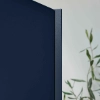 Eine blaue Schranktür mit einer Pflanze im Hintergrund, modernes Design von Nolte Küchen.