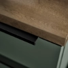 Een keukeneiland met houten blad en groene onderkast, Nolte Keukens.