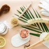 Ustensiles de nettoyage naturels, tranche de citron et sel sur fond clair.