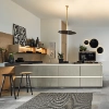 Eine moderne Küche mit Insel und Barhockern, dekoriert mit Pflanzen und Kunstwerken. Nolte Küchen.