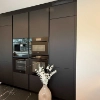 Cuisine intégrée moderne noire avec bouquet de fleurs blanches, Nolte Kitchen.