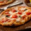 Eine frisch gebackene Pizza mit Tomaten und Basilikum auf einem Holzbrett.