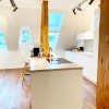 Nolte Kitchen dans une cuisine moderne avec fenêtres de toit et détails en bois.
