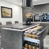Cuisine moderne avec armoires grises et îlot, conçue par Nolte Kitchen.