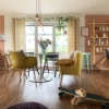 Ein modernes Wohnzimmer mit gelbem Sessel und Skateboard auf Holzboden, gestaltet von Nolte Living.