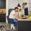 Un homme travaille dans une cuisine moderne au design noir, Nolte Kitchen.