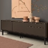 Un buffet élégant avec des vases devant un mur d'art moderne, présenté par Nolte Living.