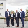 Eine Gruppe von vier Personen steht vor einem großen Schild mit der Aufschrift "Nolte Küchen".
