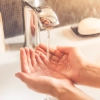 Une personne met ses mains sous l'eau courante dans la salle de bain, Nolte SPA.