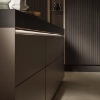 Cuisine moderne avec armoires sombres élégantes et éclairage de Nolte Kitchen.