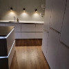 Eine moderne Küche mit Holzfußboden und beleuchteten Schränken von Nolte Küchen.