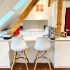 Cuisine moderne avec armoires blanches et détails en bois, équipée par Nolte Kitchen.