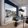 Un salon moderne avec étagère et table, entouré de rideaux. Nolte Living.