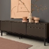 A modern sideboard with decor against a gray wall, matching Nolte Living.