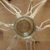 Un vase en verre suspendu dans un filet de macramé artistiquement noué.