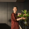 Eine Frau arrangiert Blumen in einer modernen Küche von Nolte Küchen.