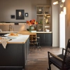 Cuisine moderne avec armoires sombres et arrangement floral, Nolte Kitchen.
