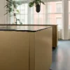 A modern kitchen with large windows and a golden island. Nolte Küchen.