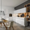Une cuisine moderne avec des armoires blanches et des accents en bois, conçue par Nolte Kitchen.