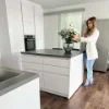 Eine Frau arrangiert Blumen in einer modernen Nolte Küchen Umgebung.
