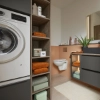 A modern bathroom with a washing machine and elegant shelves, designed by Nolte SPA.