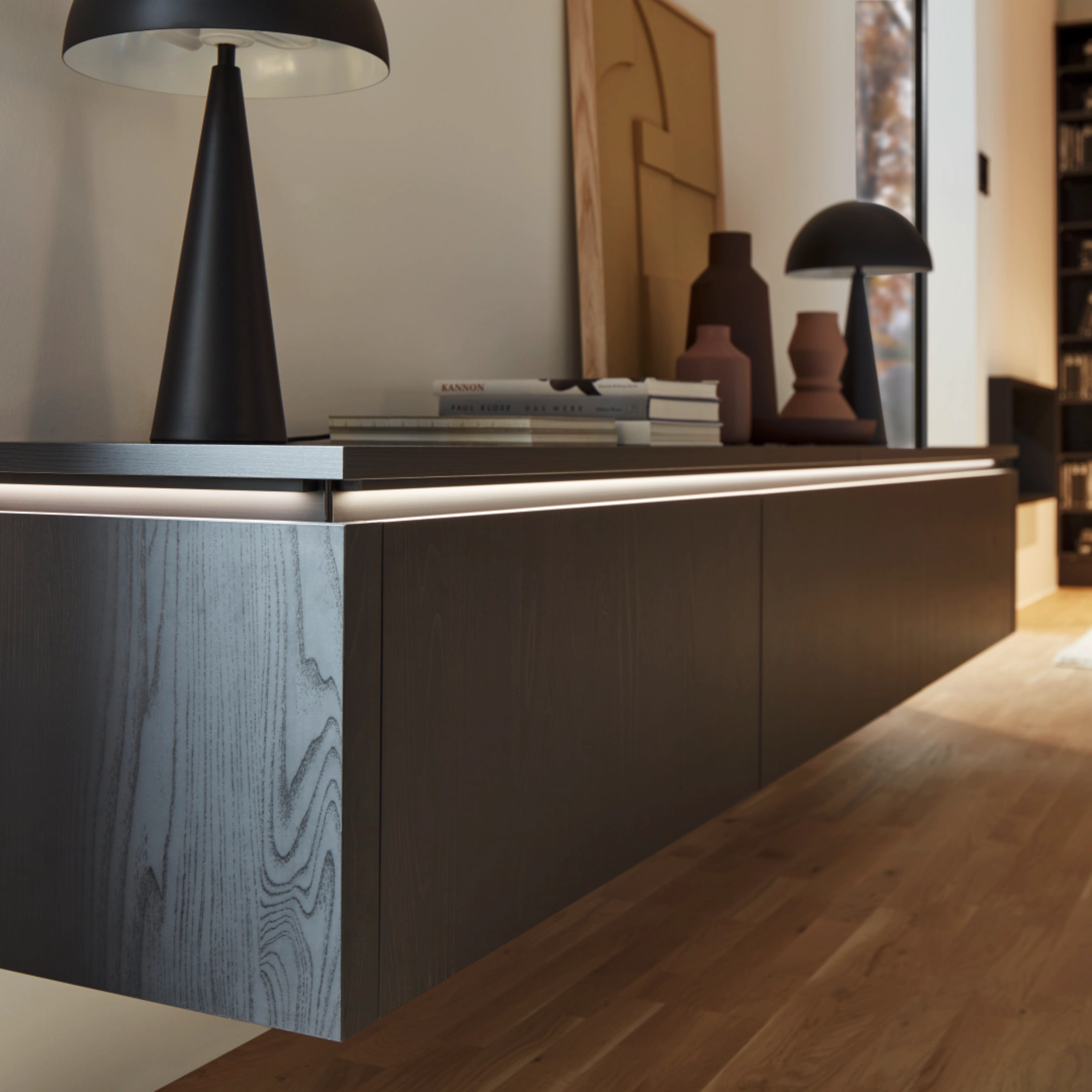 Een modern woonkamer met zwevend dressoir en decoratieve elementen; Nolte Living.