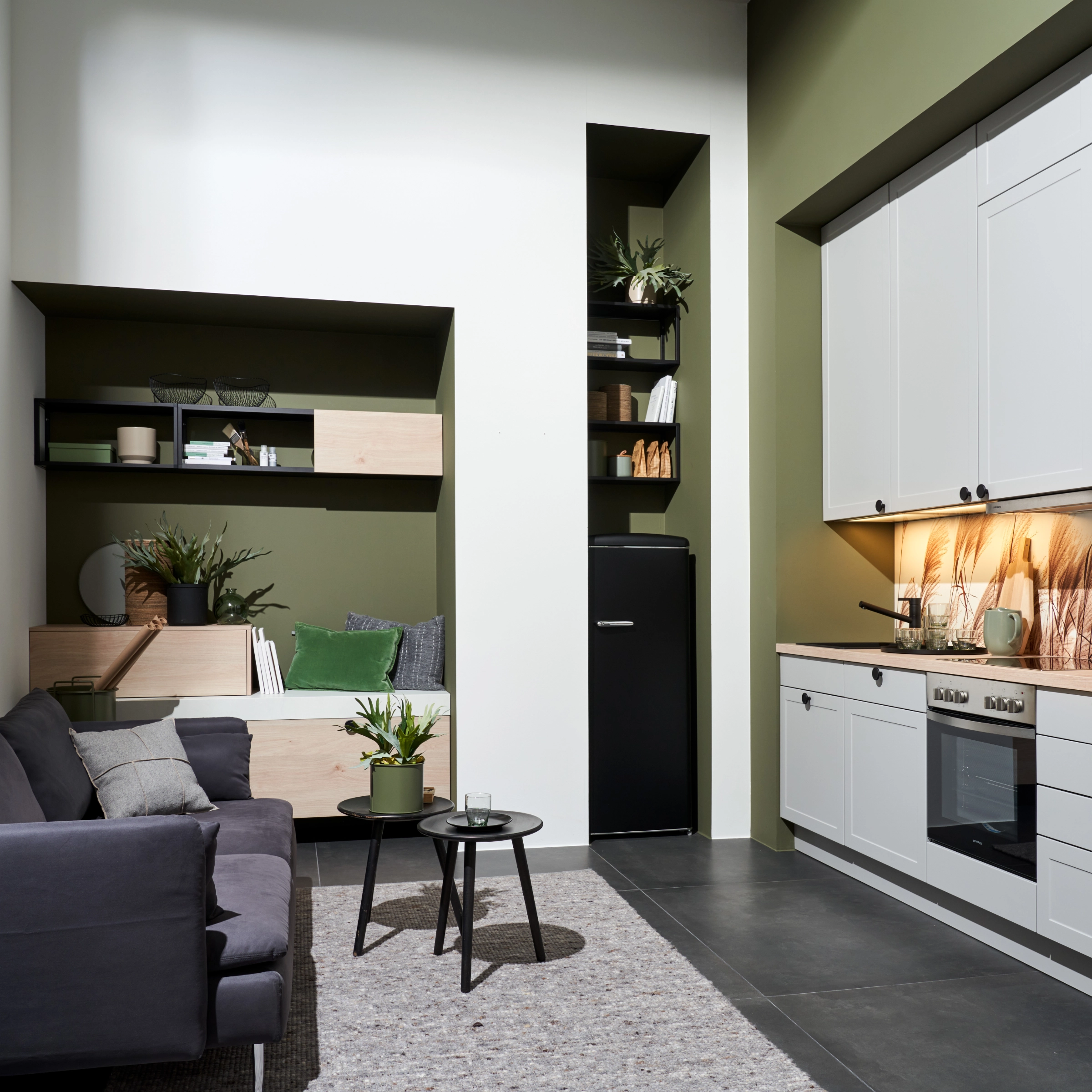 Eine moderne Küche mit grauen Schränken und grüner Wand von Nolte Küchen.