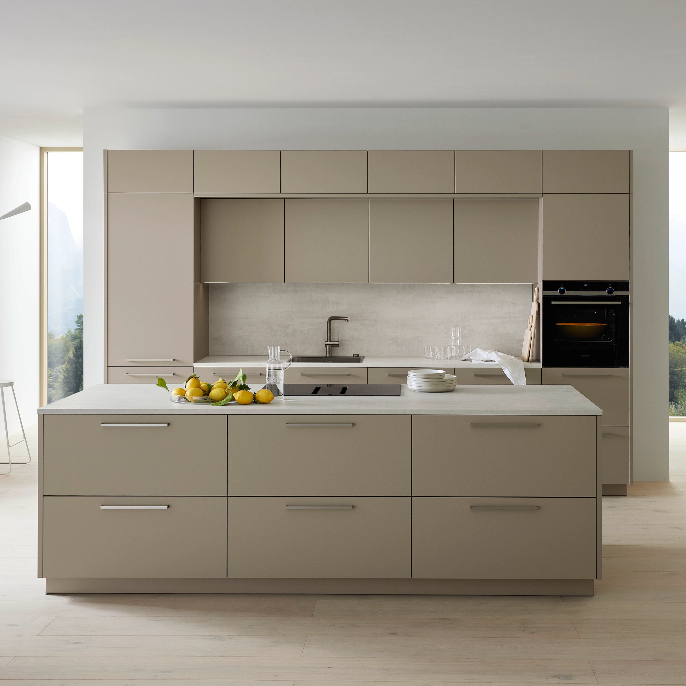 Cuisine moderne avec îlot et armoires claires, design élégant par Nolte Kitchen.