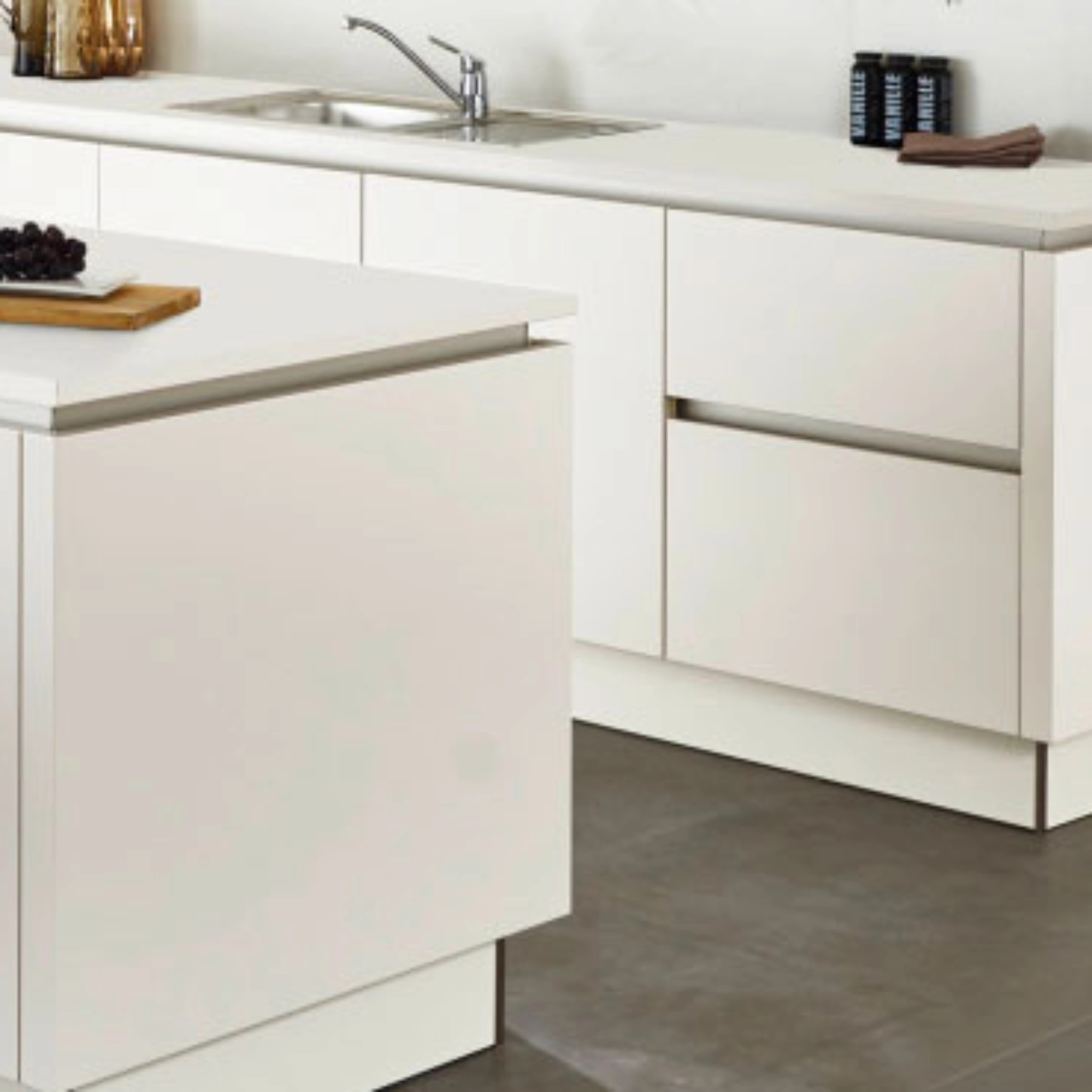 Een moderne, witte keuken met een eiland en roestvrijstalen gootsteen, Nolte Keukens.
