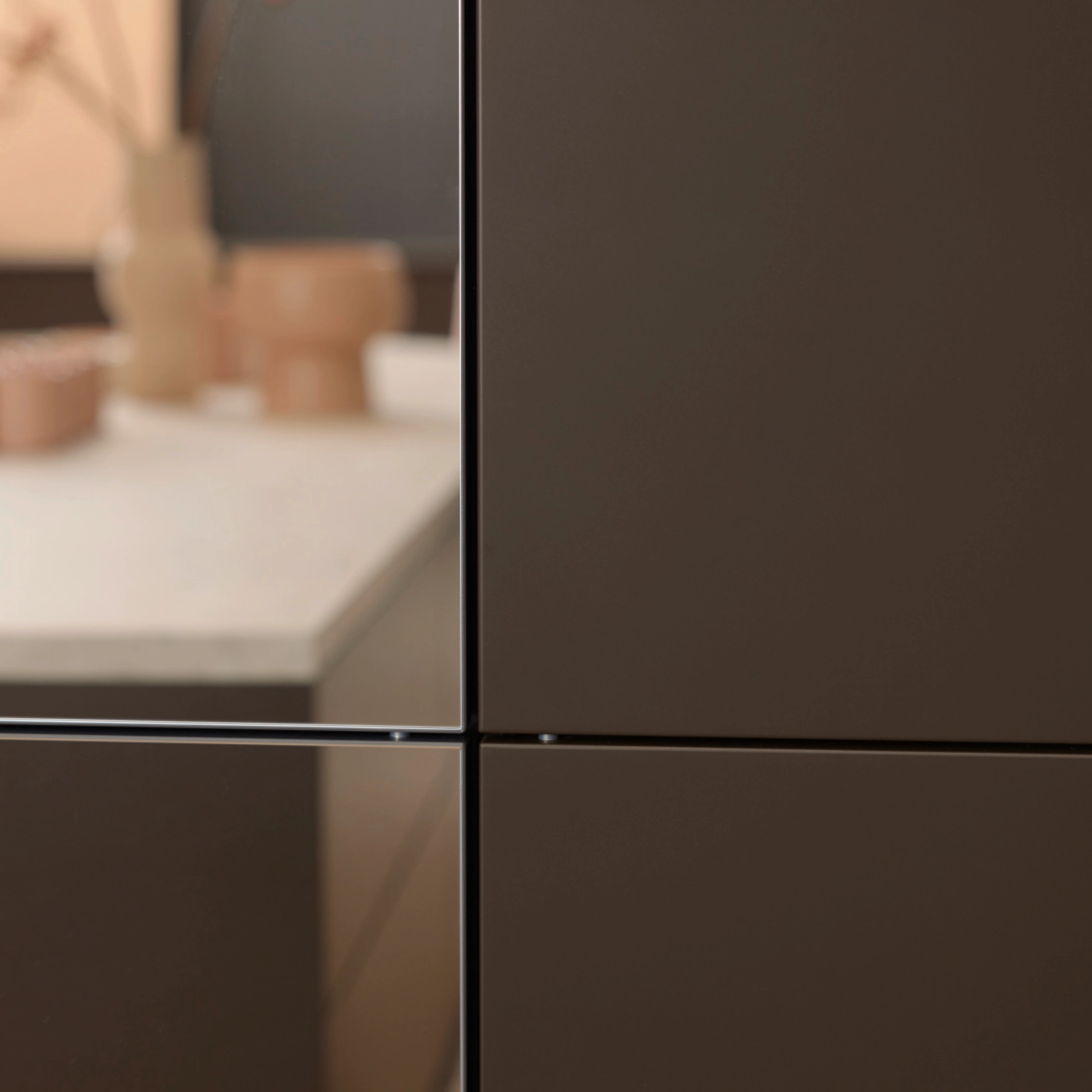 Een moderne keuken met donkere kasten en een licht werkblad, Nolte Kitchen.