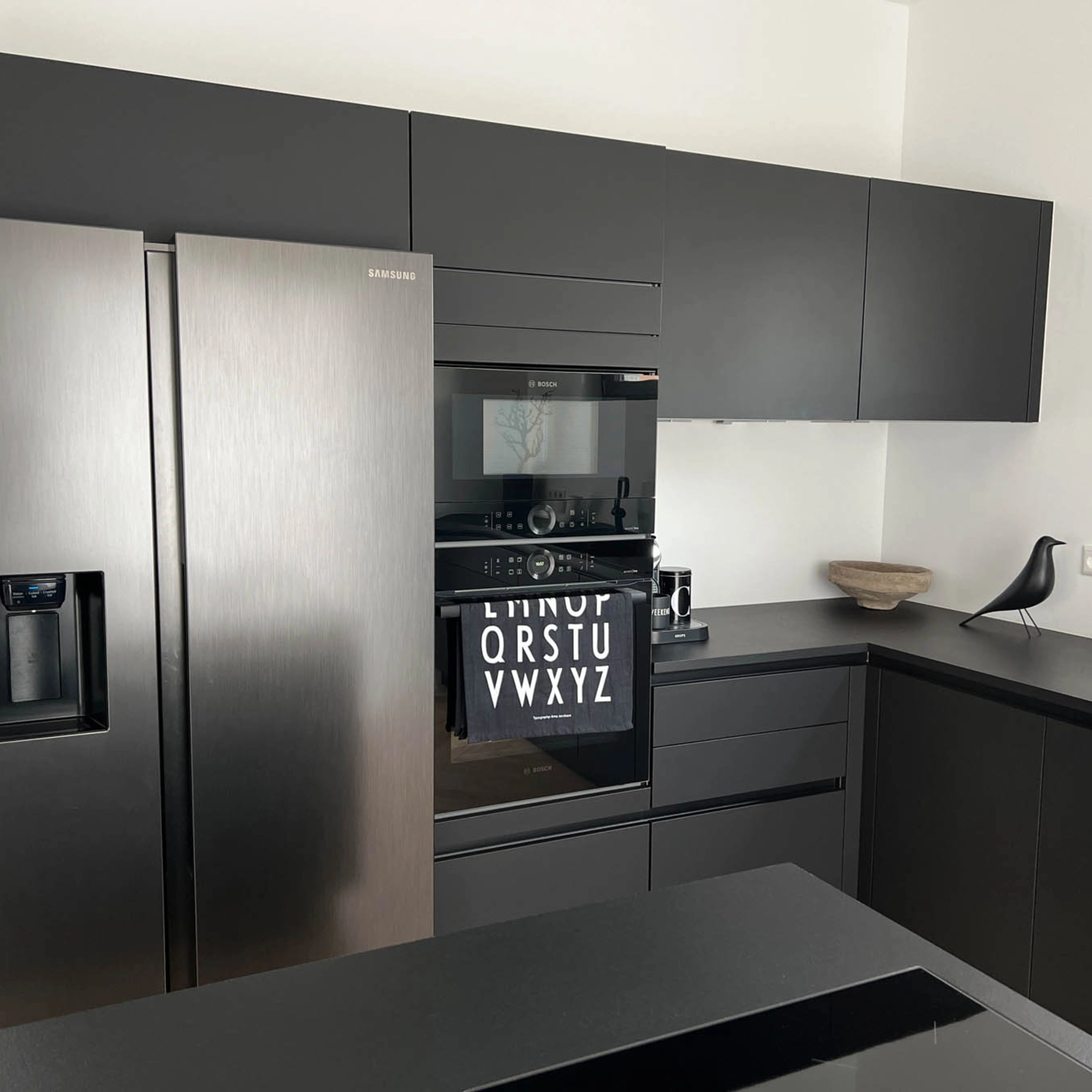 Cucina moderna con armadi neri ed elettrodomestici in acciaio inox, in stile Nolte Kitchen.