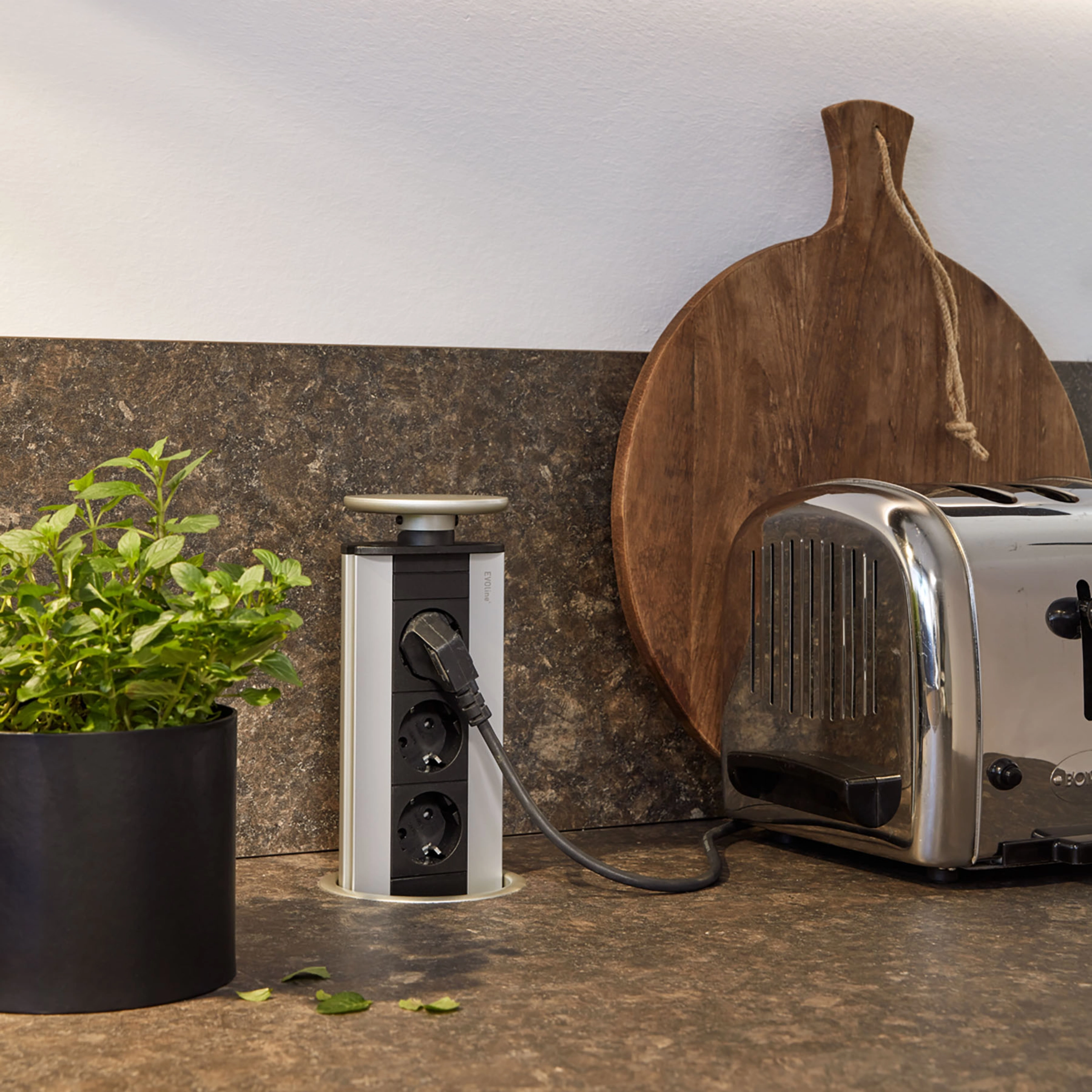 Une cuisine moderne avec grille-pain et herbes aromatiques sur le plan de travail, présentée par Nolte Kitchen.
