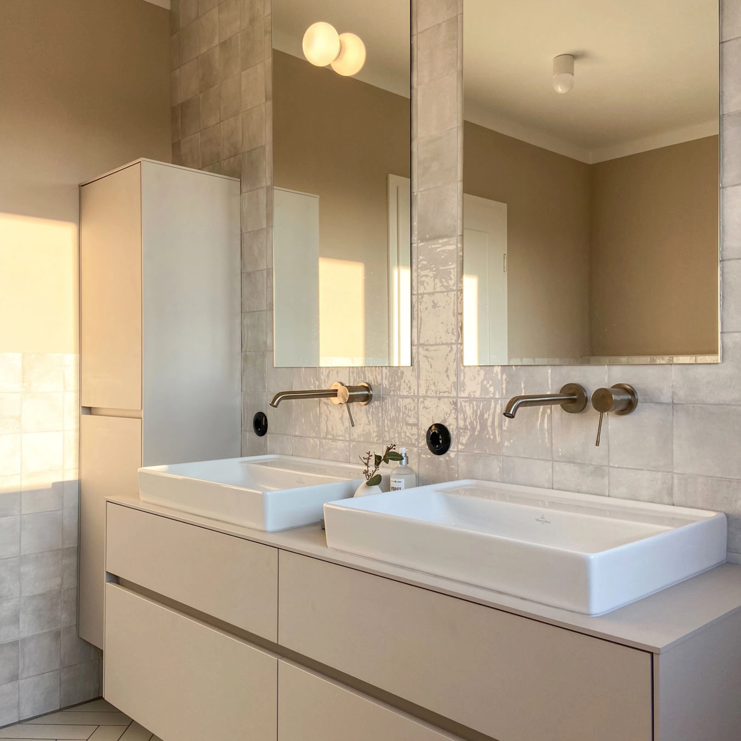 Une salle de bain moderne avec deux lavabos et un grand miroir, partie du Nolte SPA.