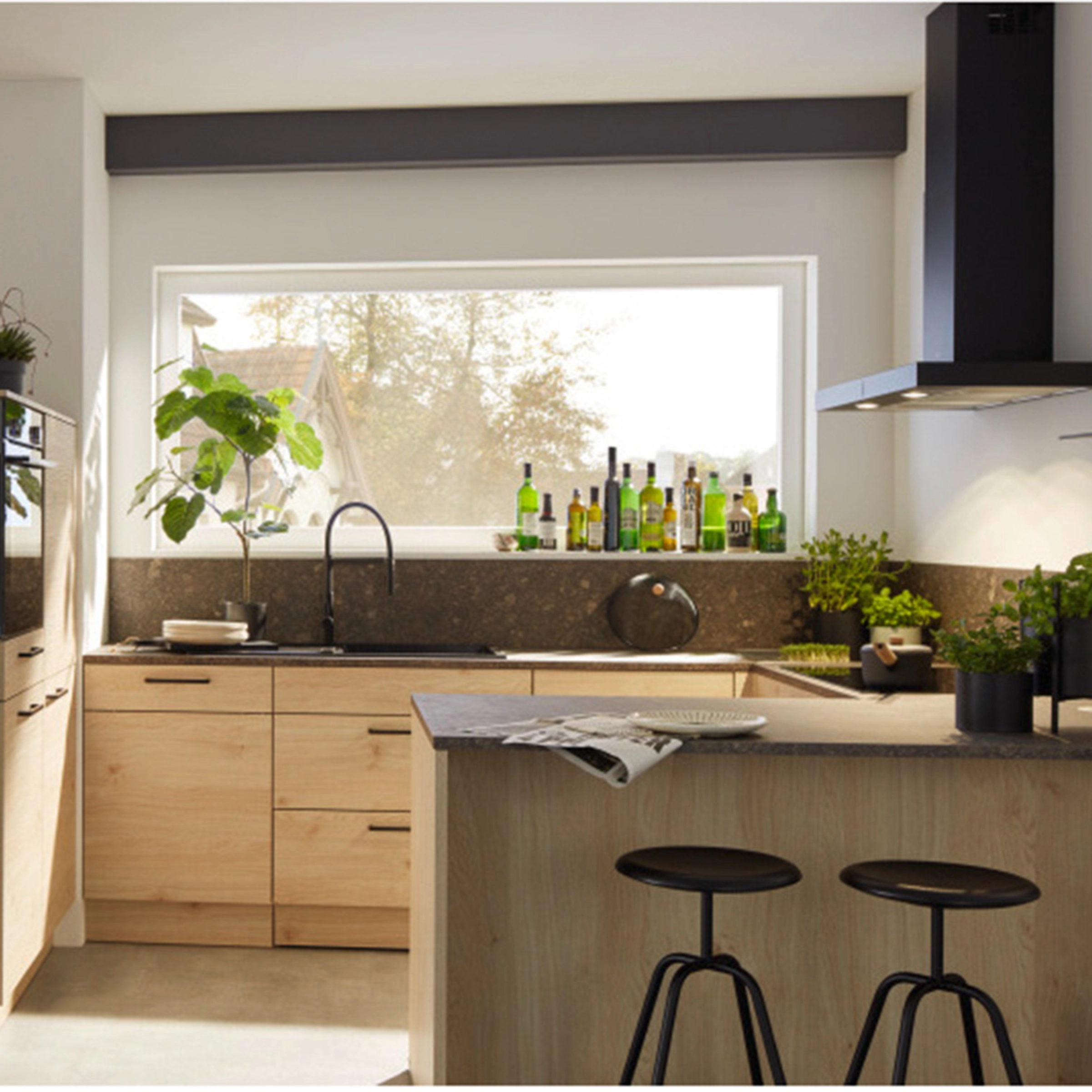 Cuisine moderne avec armoires en bois et plantes, éclairée par une grande fenêtre. Nolte Kitchen.