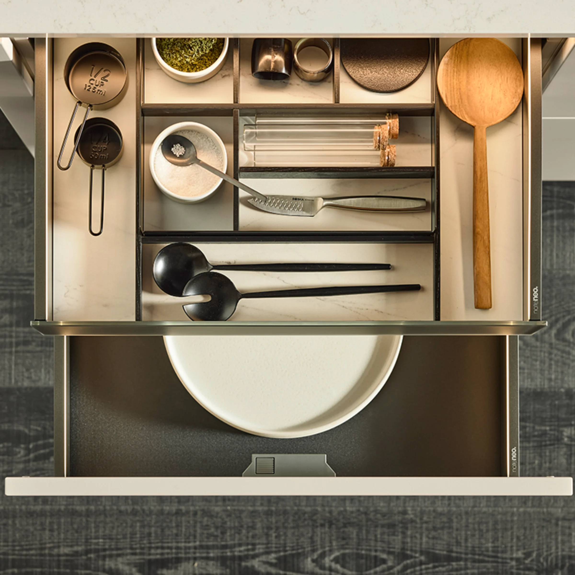 Eine geöffnete Küchenschublade mit gut organisiertem Besteck und Gewürzen. Nolte Küchen.