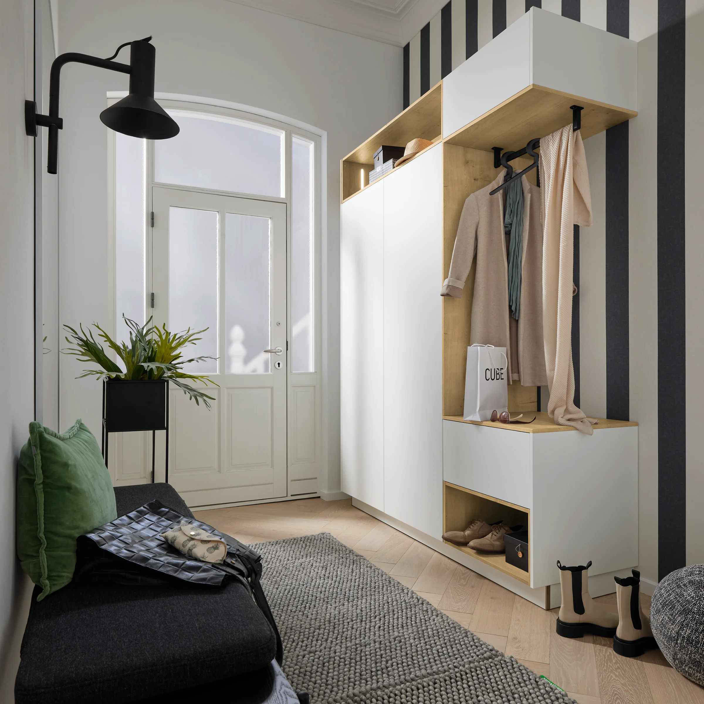 Un hall d'entrée élégant avec penderie, banc et décoration, idéal pour Nolte Living.