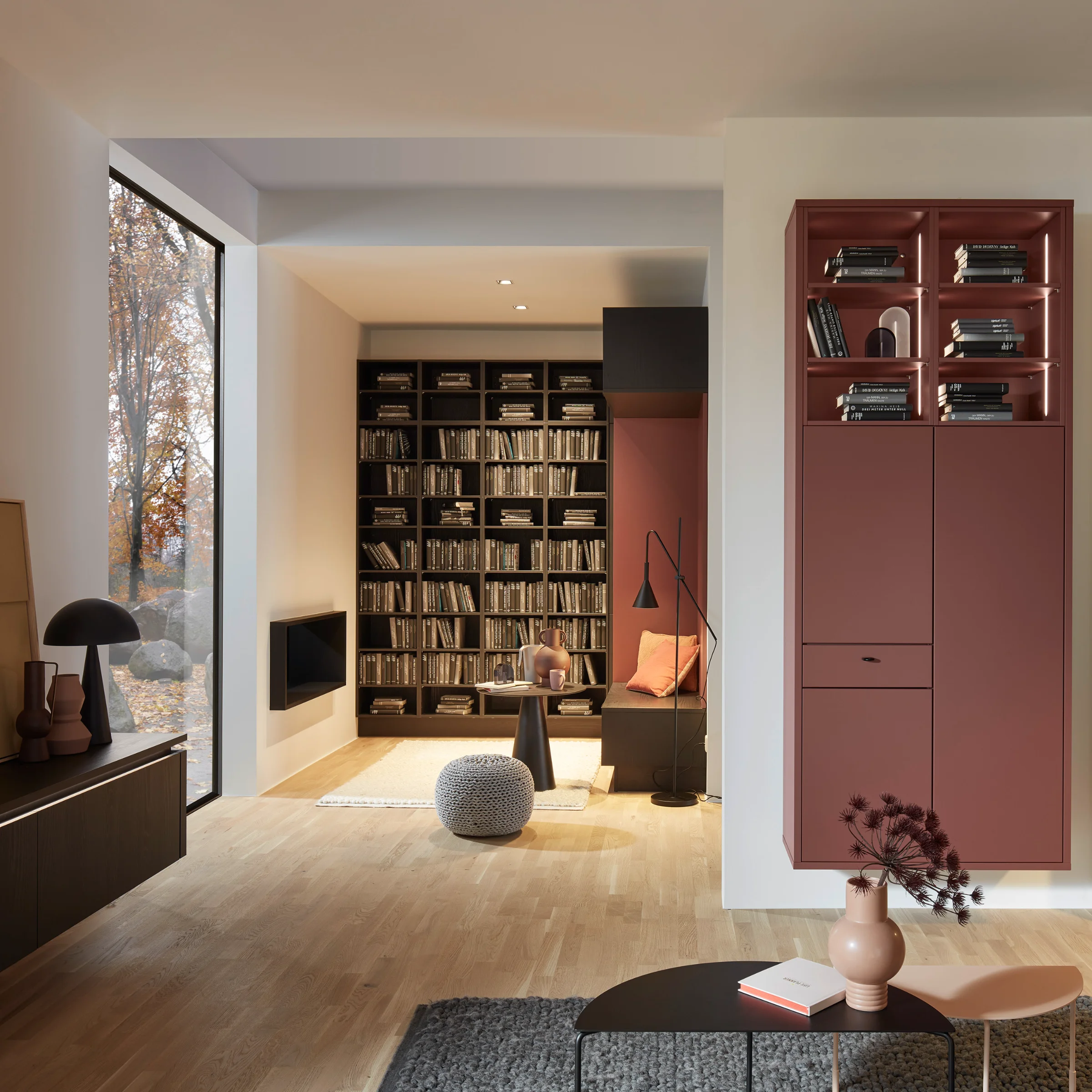 Un salon moderne avec étagères et coin salon confortable, intégré dans Nolte Living.