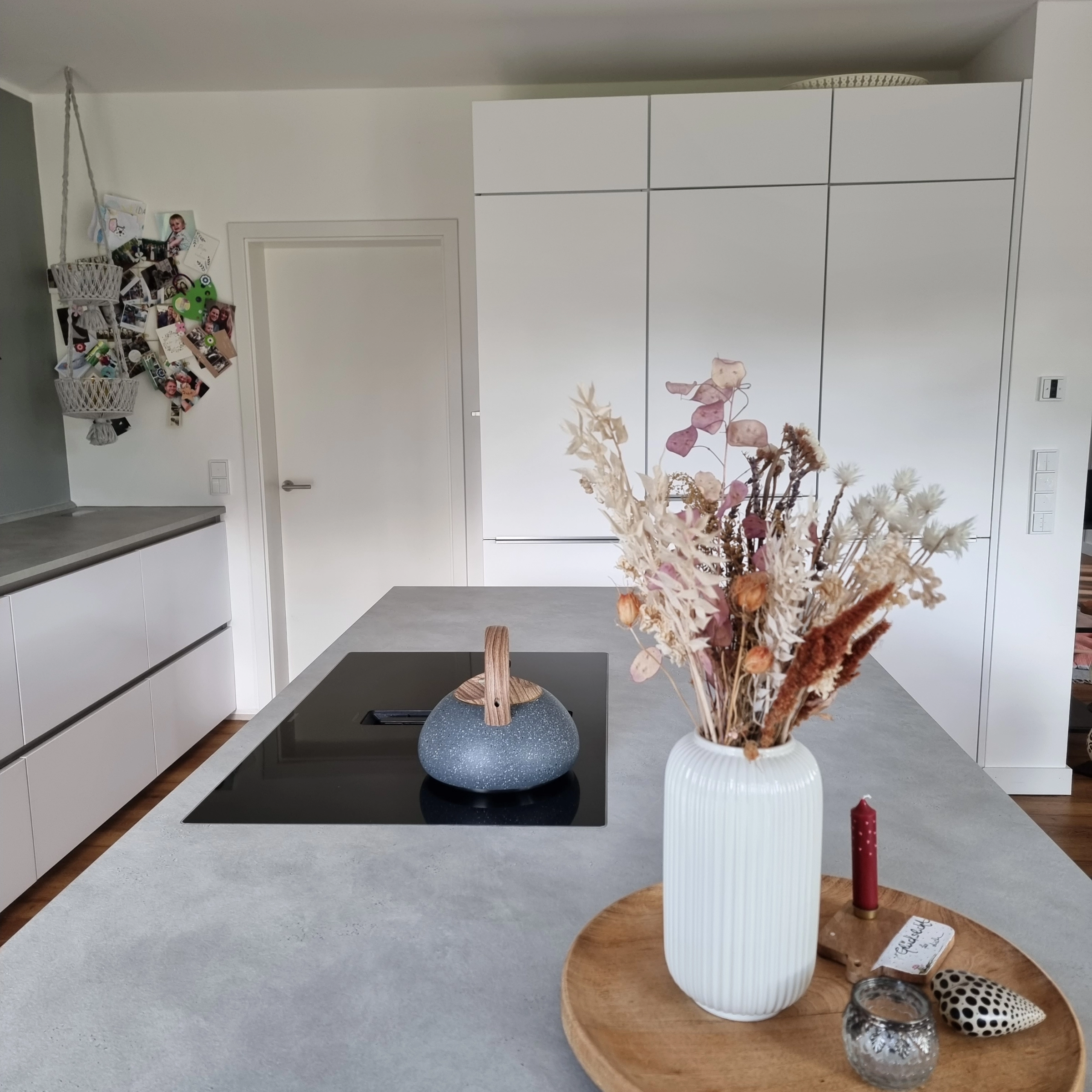 In de moderne keuken met kookeiland en decoraties staat "Nolte Kitchen" voor stijlvol design.