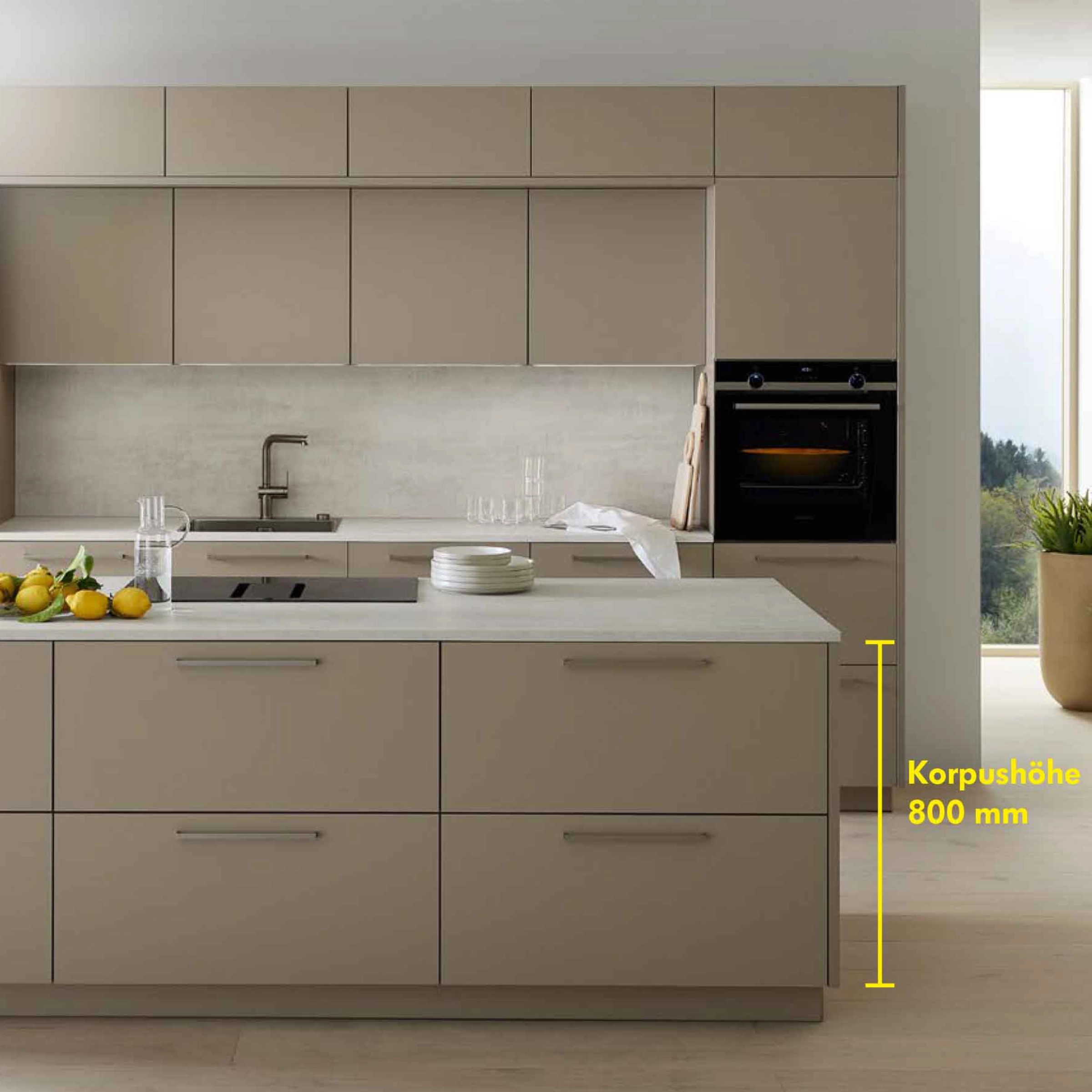 A modern kitchen with an island and beige fronts, presented by Nolte Kitchen.